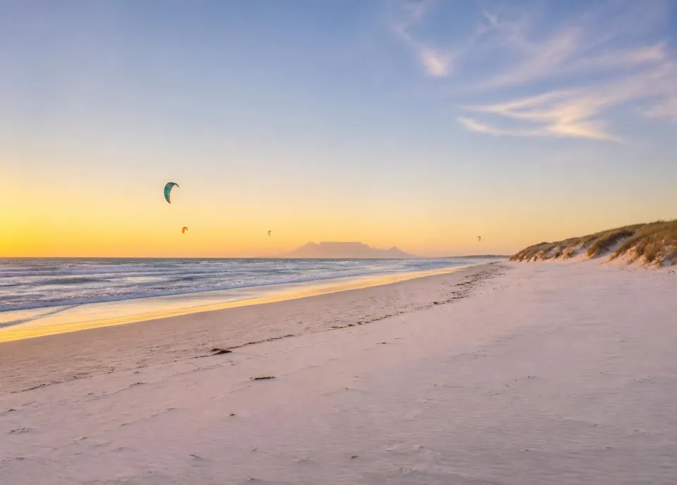 Strand von Melkbosstrand bei Sonnenuntergang mit dem Tafelberg in der Ferne