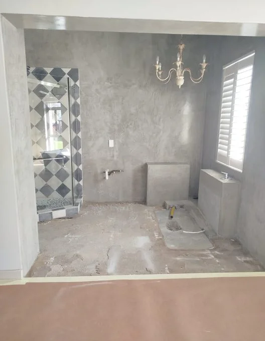 Badkamer in aanbouw met douche en kroonluchter